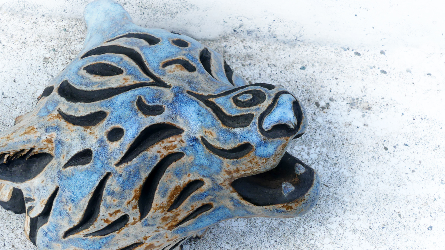 Céramique sculpture tête de loup hurlant, gravures tribales, émail bleu cristal