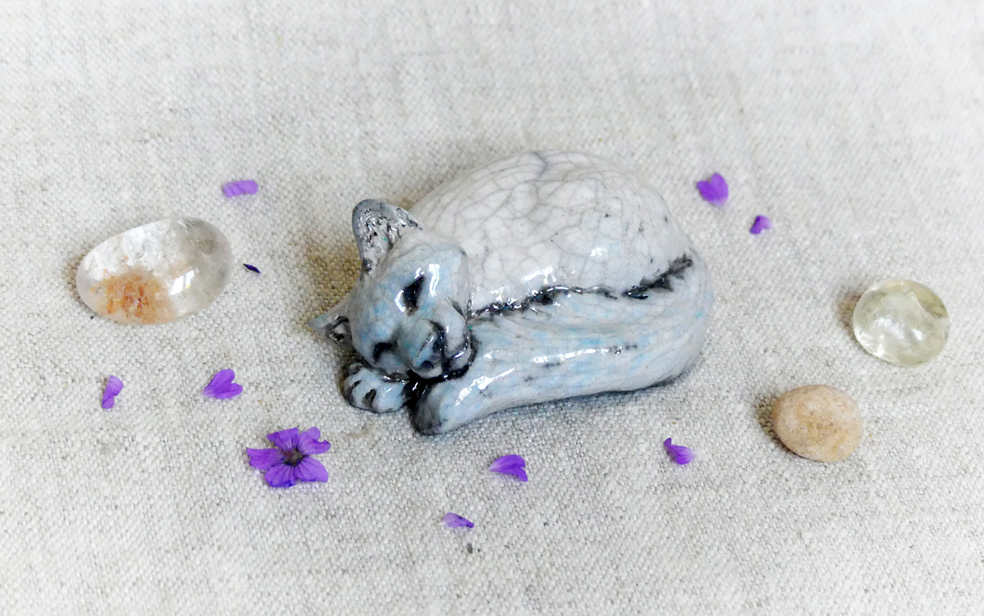 Petit chat blanc et turquoise couché en rond en céramique cuisson raku