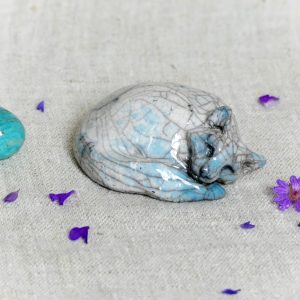 Chat endormi en rond du Petit Peuple