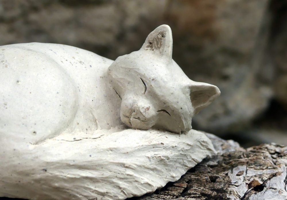 Petit chat blanc endormi en grès blanc